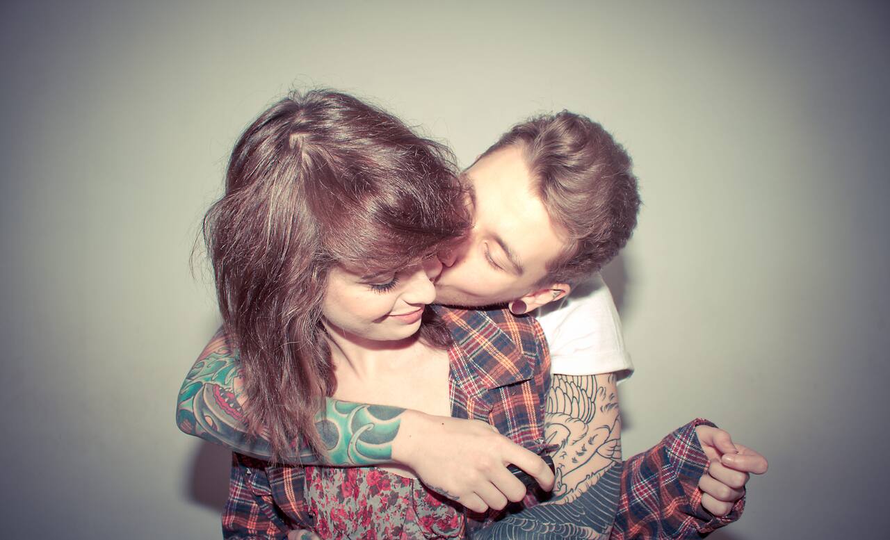 A young couple is kissing