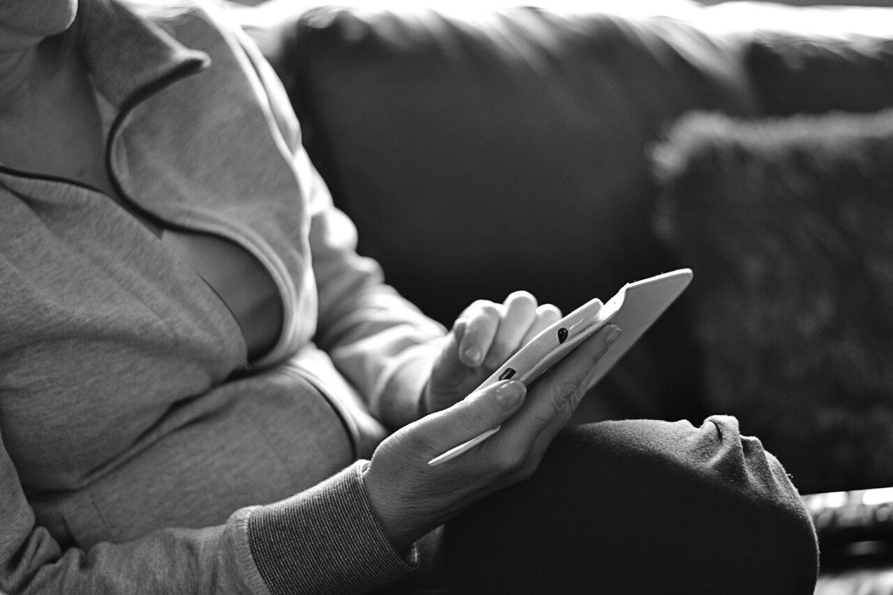 A man is holding a phone in his right hand; the image is in black and white